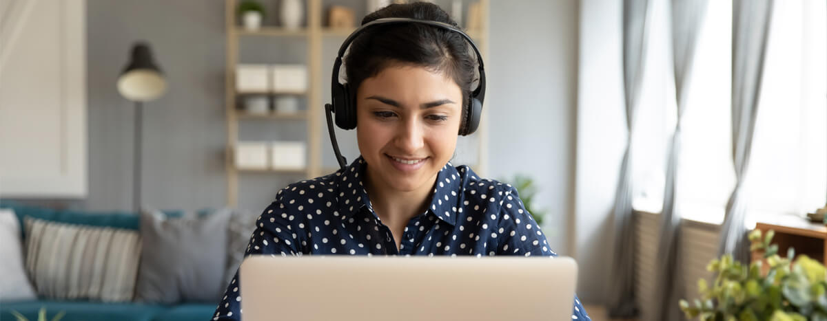 A woman smiling in front of her laptop