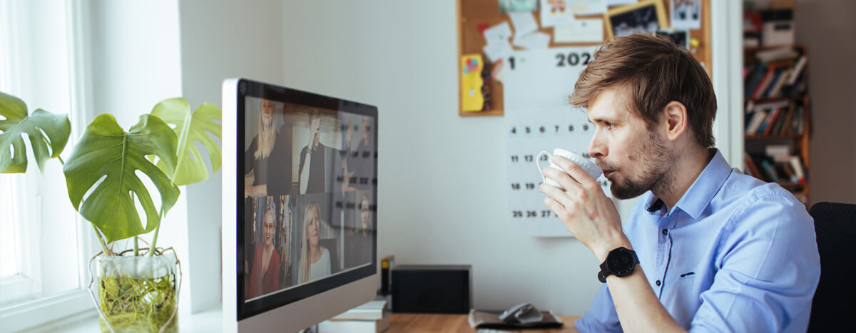 A guy drinking coffee in front of his computer