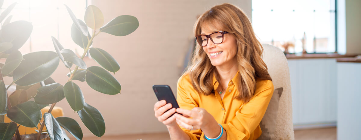 A woman smiling in front of her phone