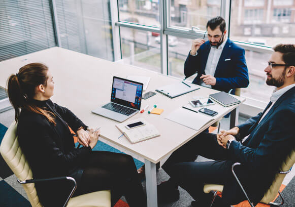 Three people working together around a table