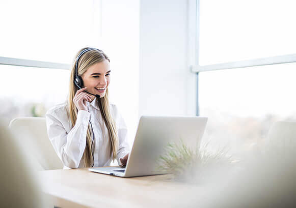 A woman on a call in front of her laptop