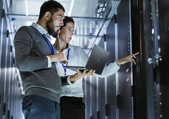 Two people working on a server room
