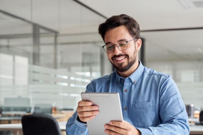 Man looking at his tablet and smiling