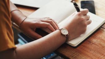 hands writting on a notebook