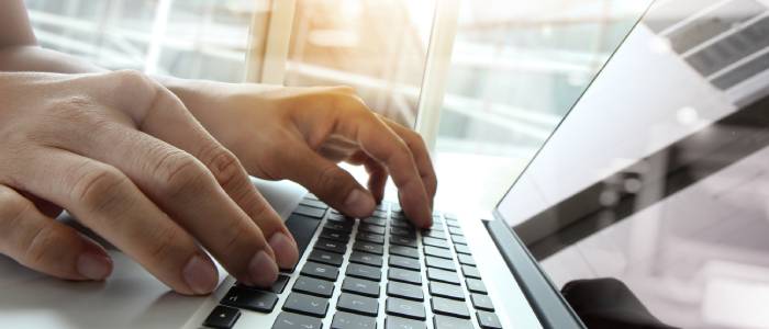 Someone typing on a laptop