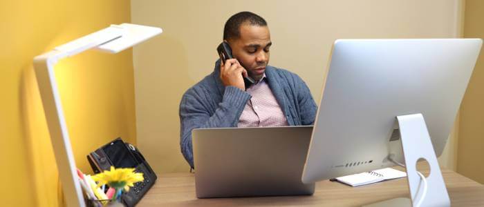 Someone on the phone in front of a computer