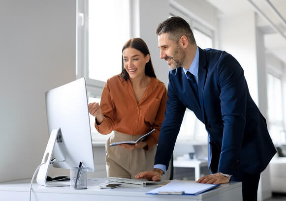 Two people looking at a computer monitor
