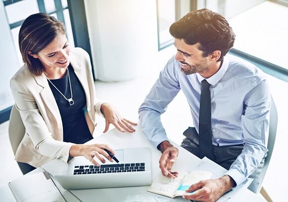 Two people collaborating in front of a laptop