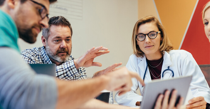 Des personnes qui discutent devant une tablette