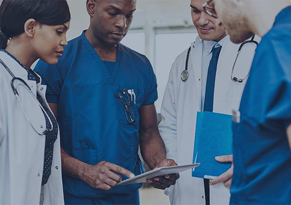 Group of doctors and nurses looking at a tablet