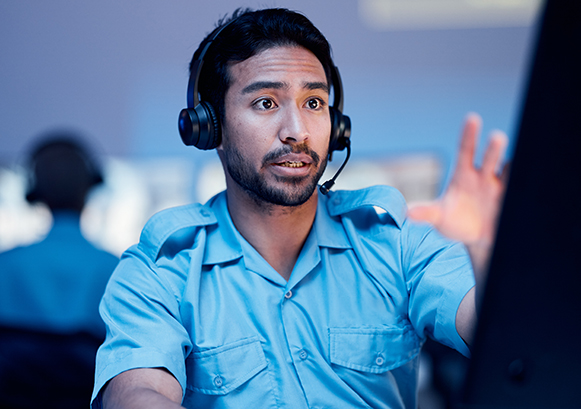 Un homme au telephone avec un casque devant son ordinateur