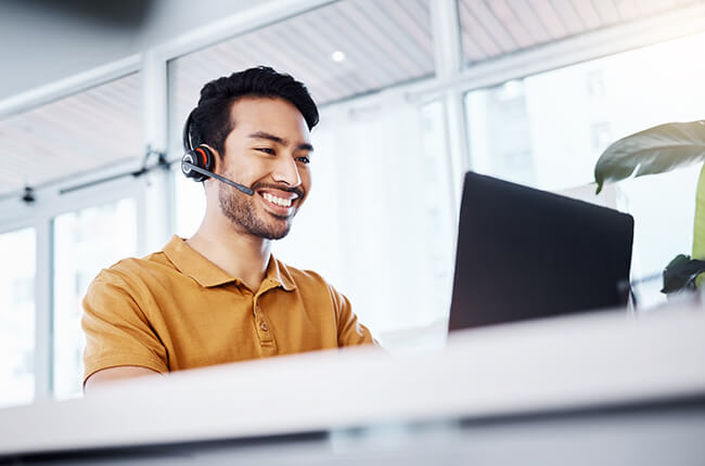 Man with headset on laptop
