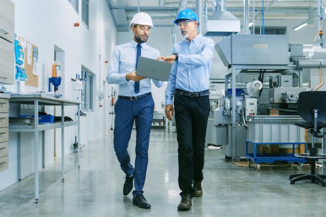 Two guys walking in a factory