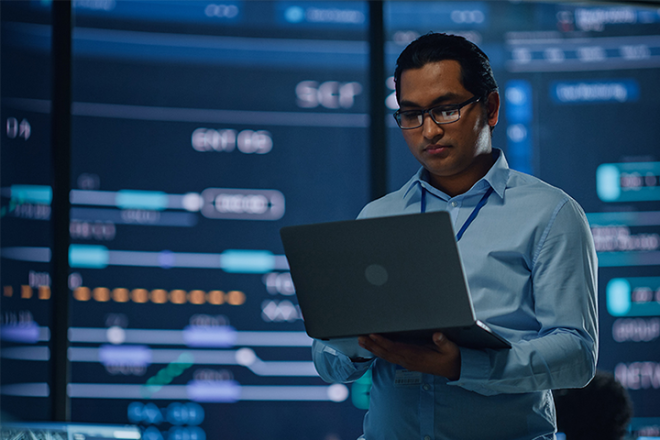 Man in the office holding a laptop