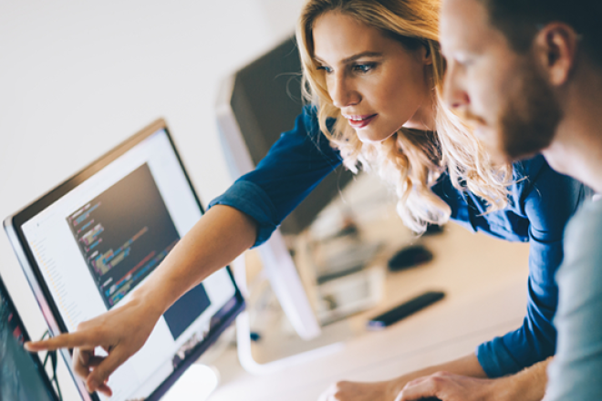 A couple of people looking at a monitor