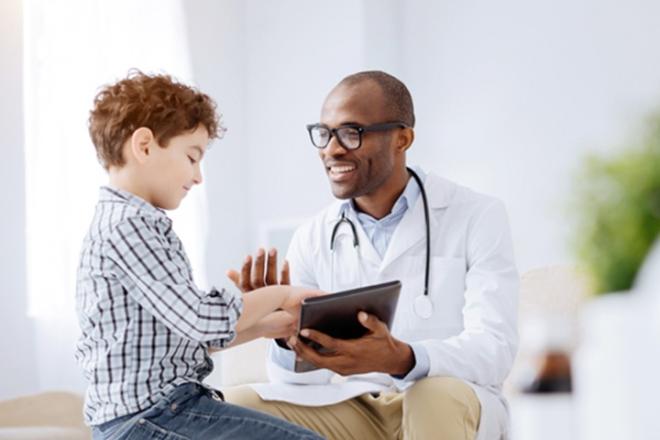 A doctor and a child looking at a tablet