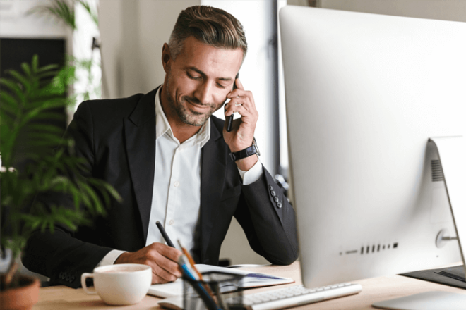 A guy on a phone on his desk