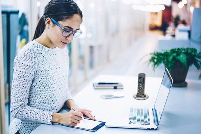A woman working on her desk and taking notes