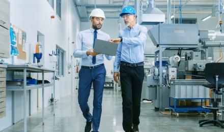 Two guys walking in a factory