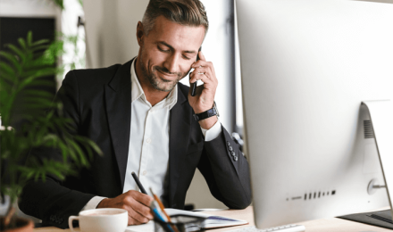A guy on a phone on his desk