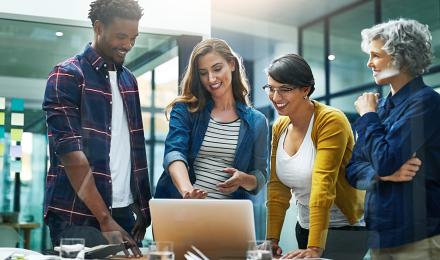 group of people talking and looking at a laptop