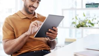 Man smiling and looking at a tablet