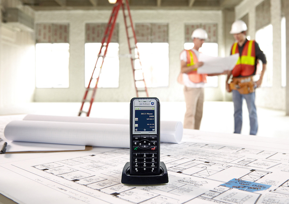 Workers looking at a plan and a phone in the front