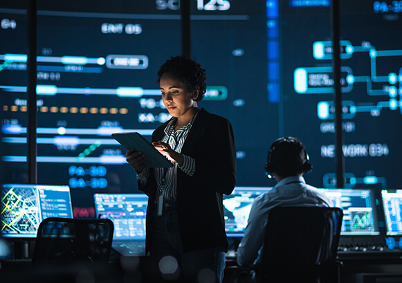 A woman looking on an iPad on a center of command room