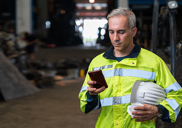 A field worker, looking at his phone