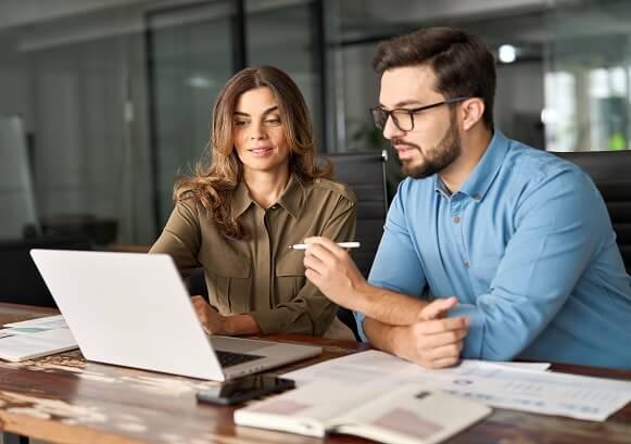 Two people collaborating in front of a laptop