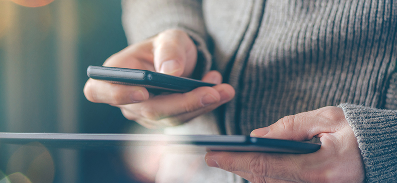 Someone looking at both a phone and a tablet