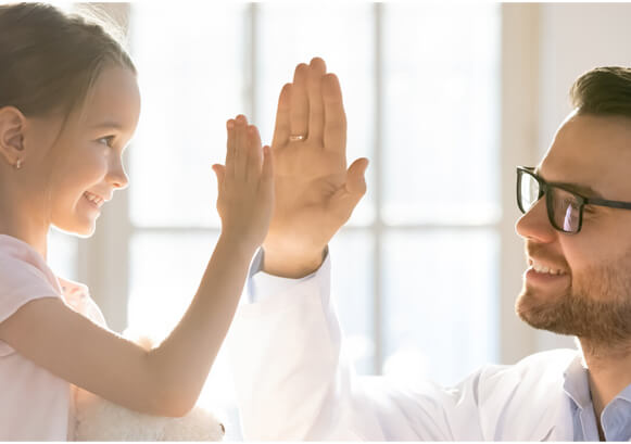 A young girl and a doctor clapping hands