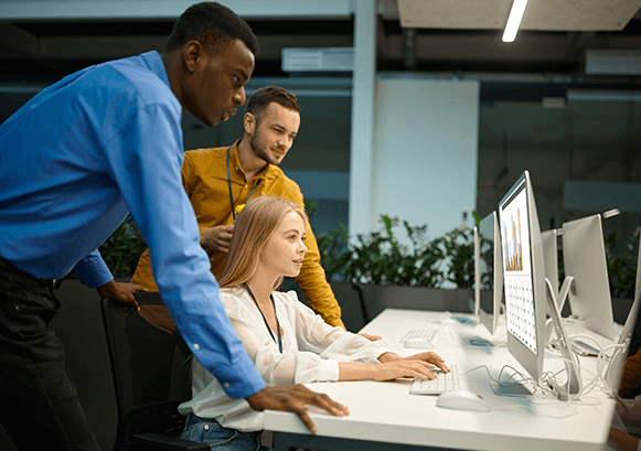 Three people working in front of a computer