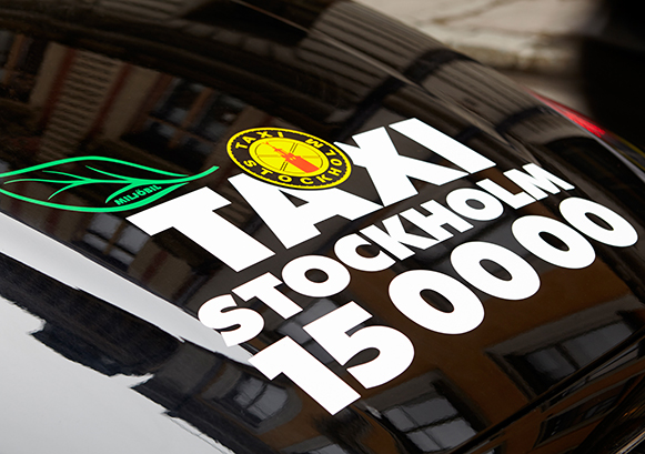 Back of a car window with a Taxi stickers on it