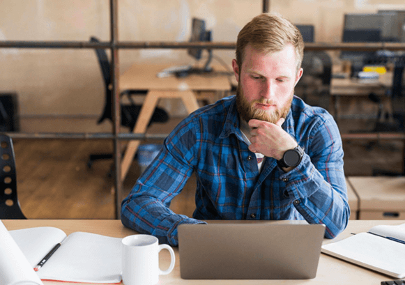 Man looking at his laptop and thinking