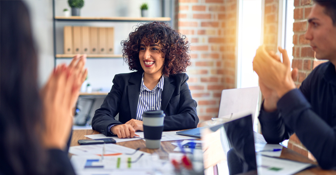 Group of people around a table in the office smiling at each other