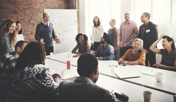 A big group in meeting looking at someone looks like the leader