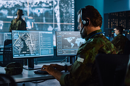 A guy in front of multiple monitors in a control center