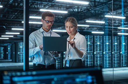 Two people working in a server room