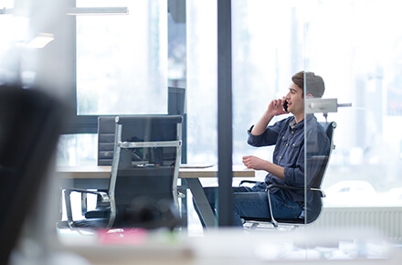 A man on a phone call at his desk