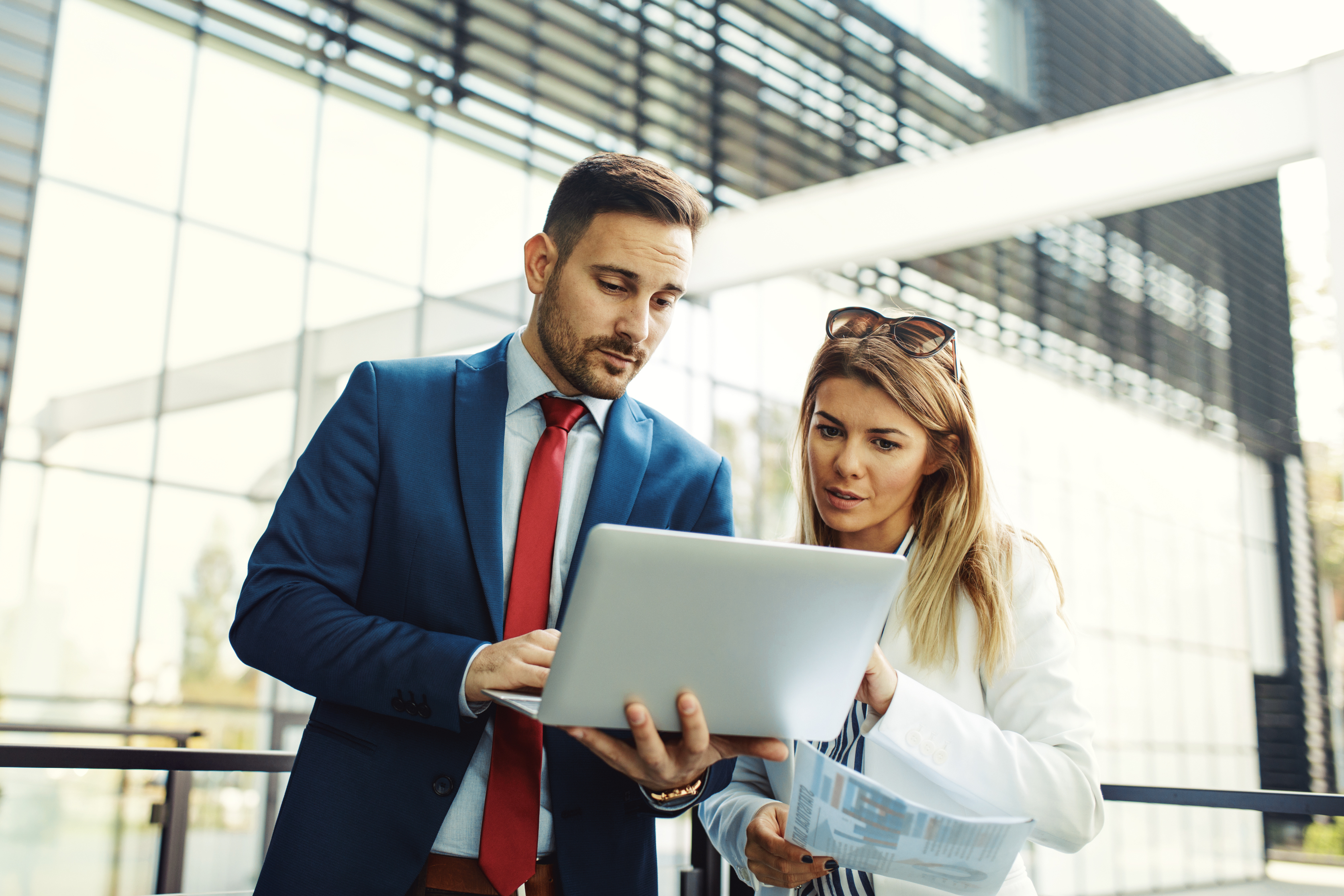 Two persons looking at a laptop in a working outfit
