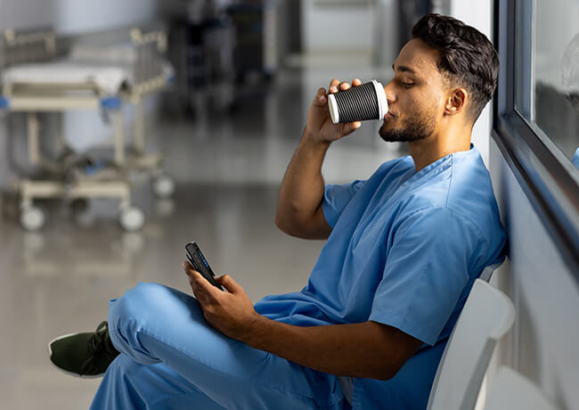 Healthcare person drinking coffee and checking DECT phone