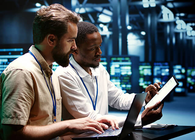 Men in data centre with laptops