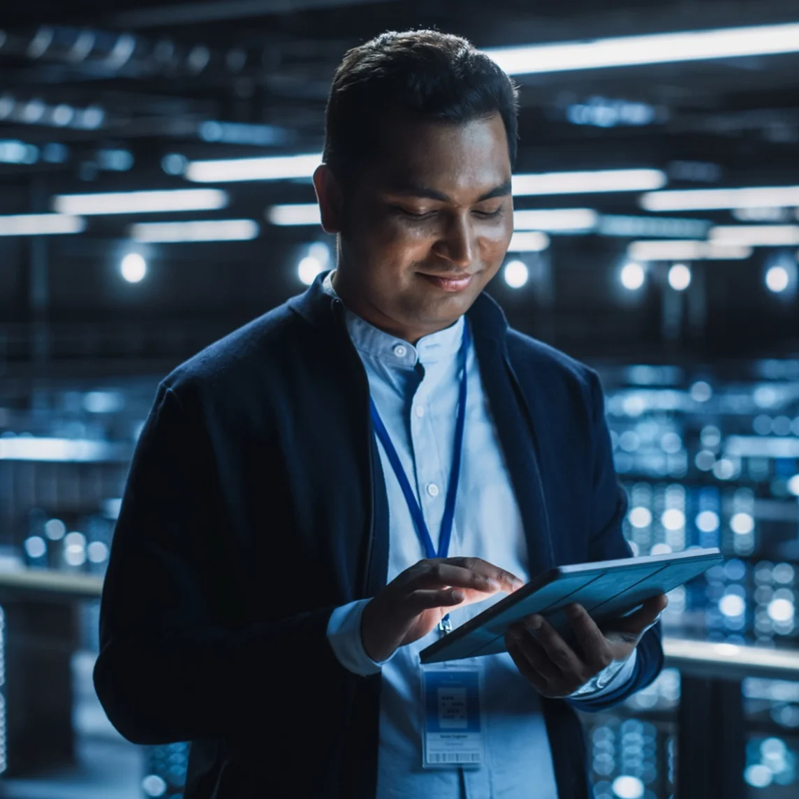 IT professional reviewing a tablet in a data center