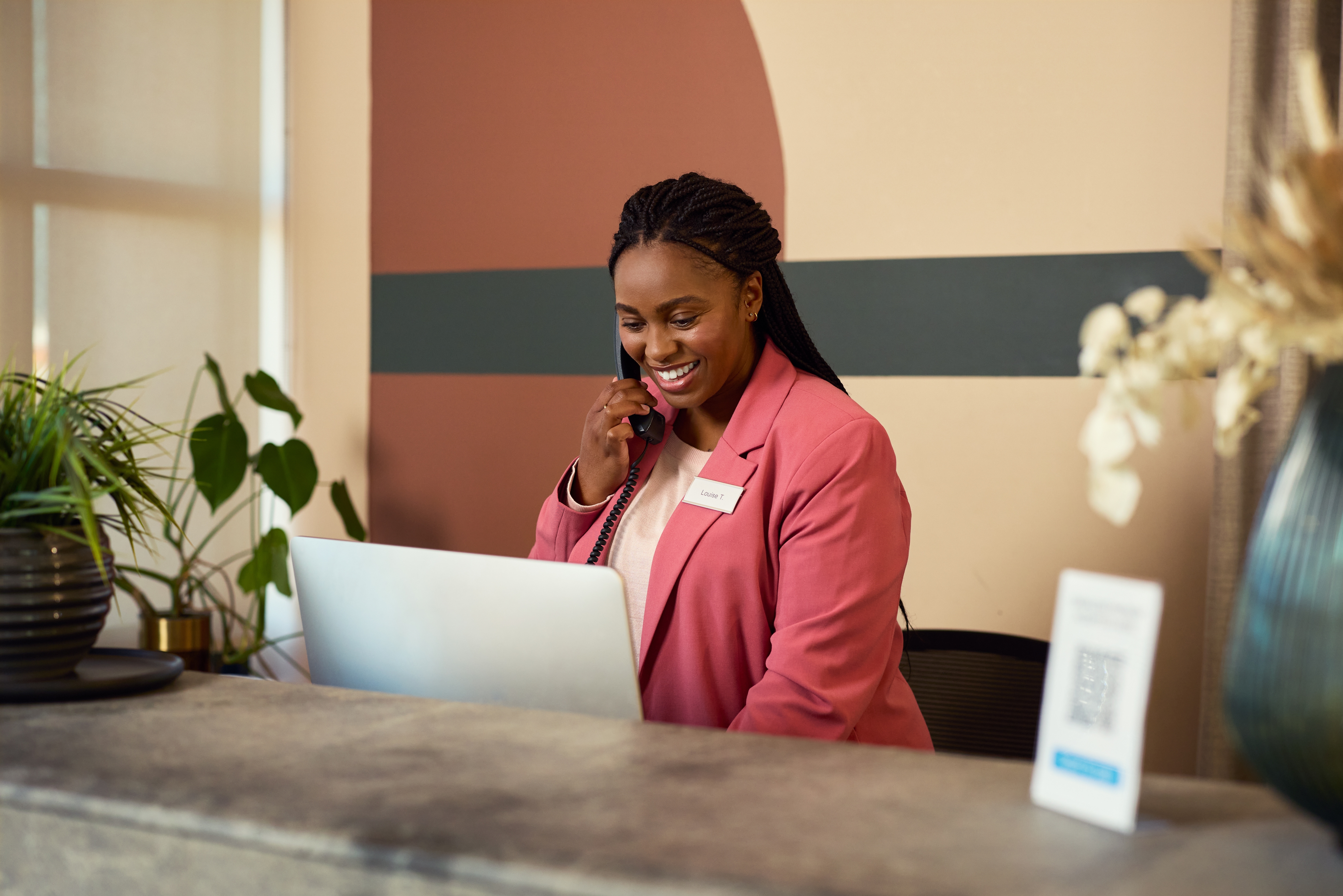 Woman working in a hotel calling and checking her laptop