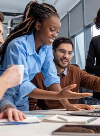 Four people collaborating in front of a laptop