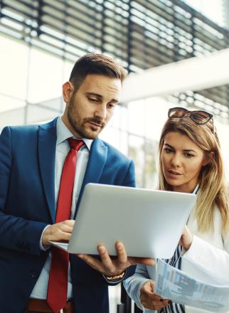 Two persons looking at a laptop in a working outfit