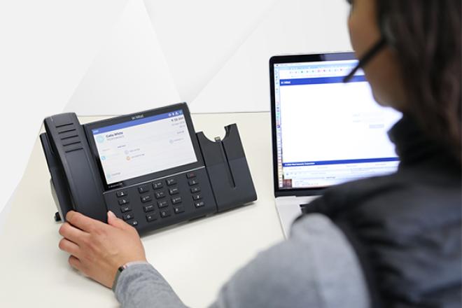 A woman in front of a business phone system